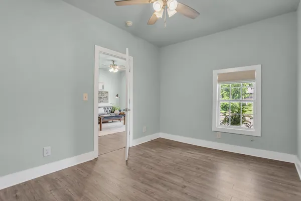 an empty room with wooden floor and a window