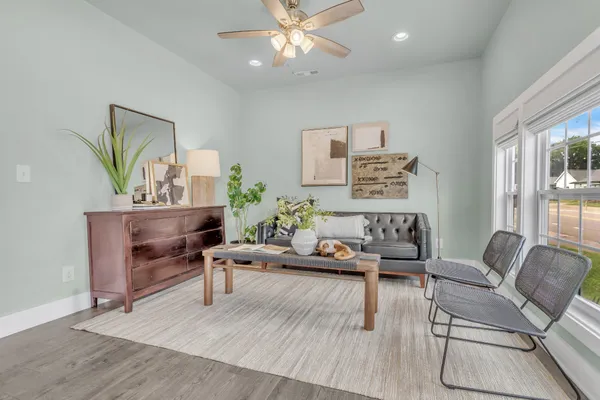 a living room with furniture and a wooden floor