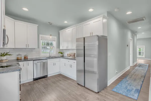 a kitchen with stainless steel appliances granite countertop a refrigerator sink and cabinets