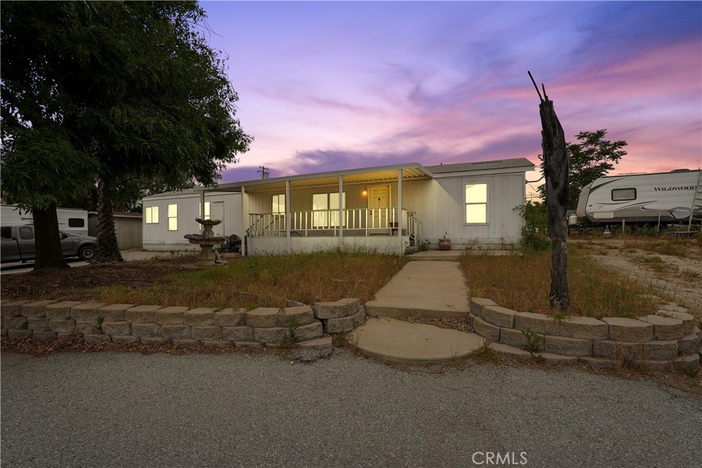a view of a house with backyard and a tree