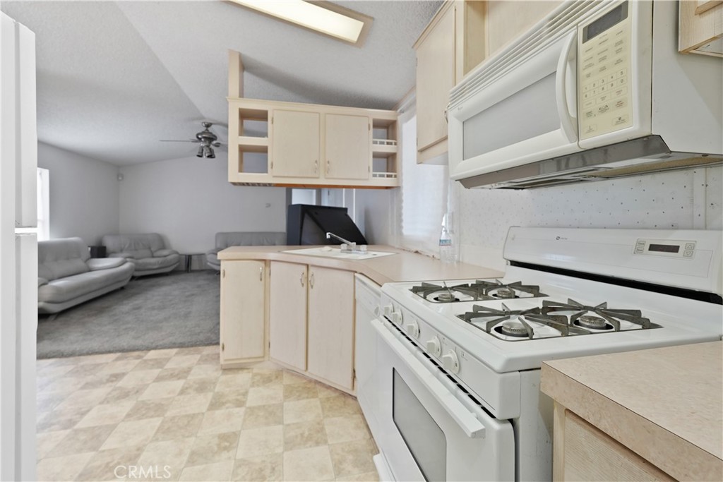 18420 Decker Road Perris, CA 92570 - Photo 15 of 26 a kitchen with a stove a sink and a refrigerator
