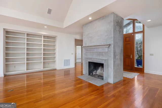 a view of an empty room with a fireplace and a window