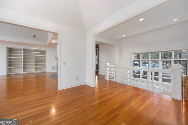 a view of an room with wooden floor fan and windows
