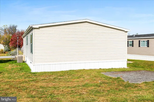 a view of a white house next to a yard