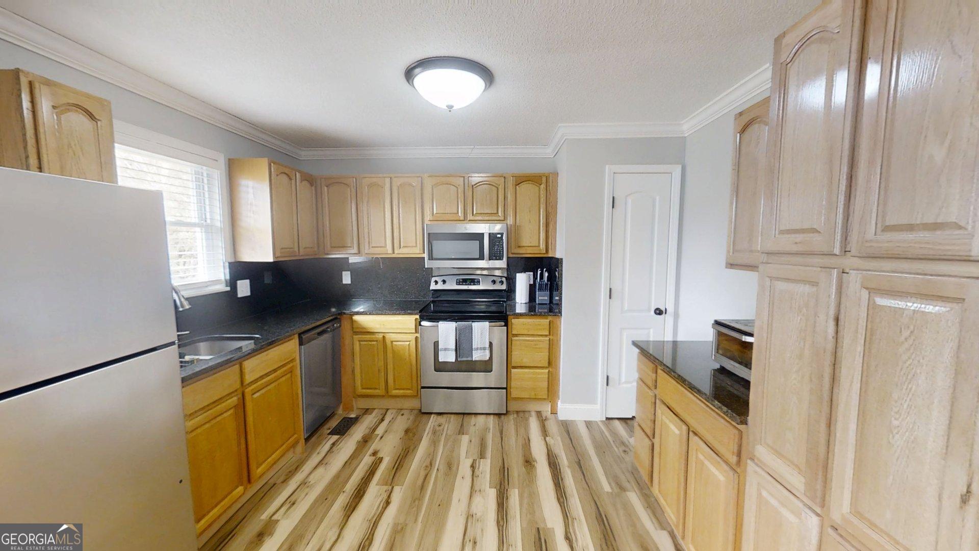 906 Diamond Circle LaFayette, GA 30728 - Photo 7 of 26 a kitchen with granite countertop cabinets a sink a window and stainless steel appliances