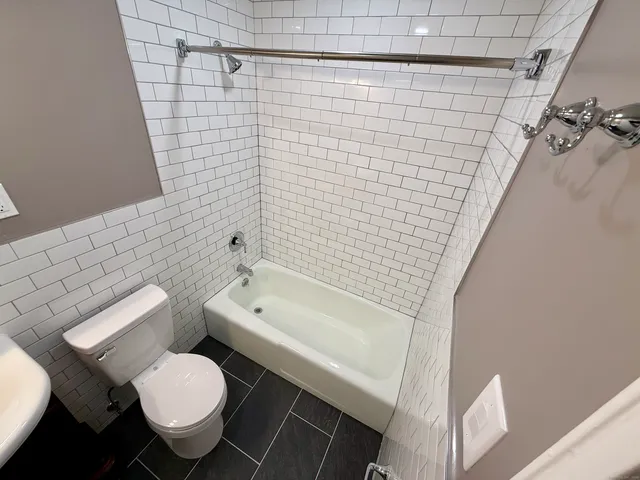 a bathroom with a toilet and a shower