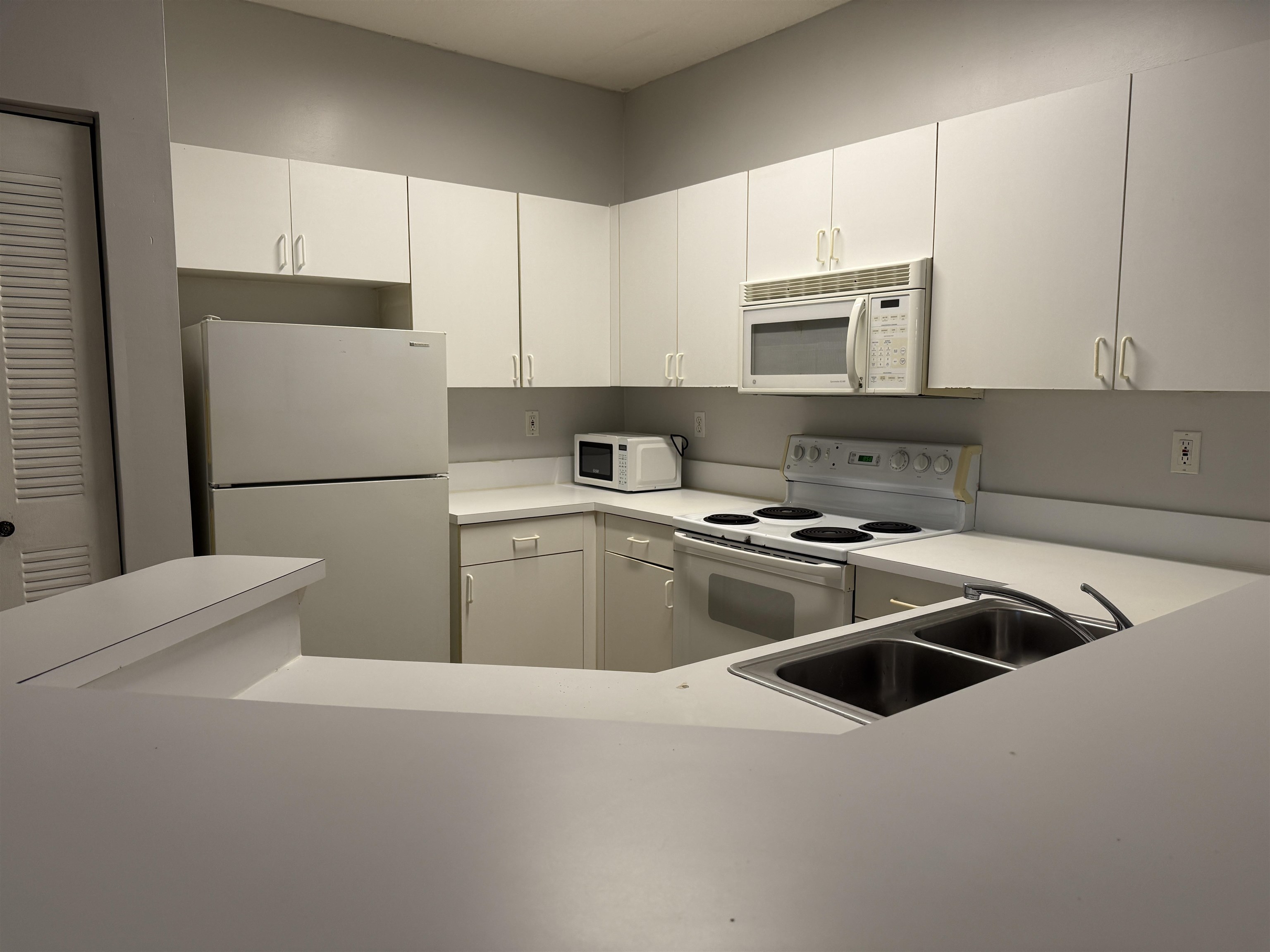 550 Florida Club Boulevard, Unit 205 St. Augustine, FL 32084 - Photo 4 of 10 a kitchen with a sink a stove and refrigerator