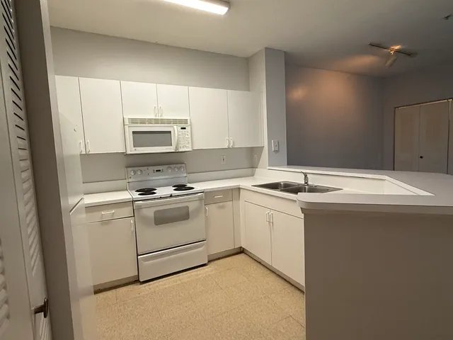 a kitchen with a sink stove and microwave