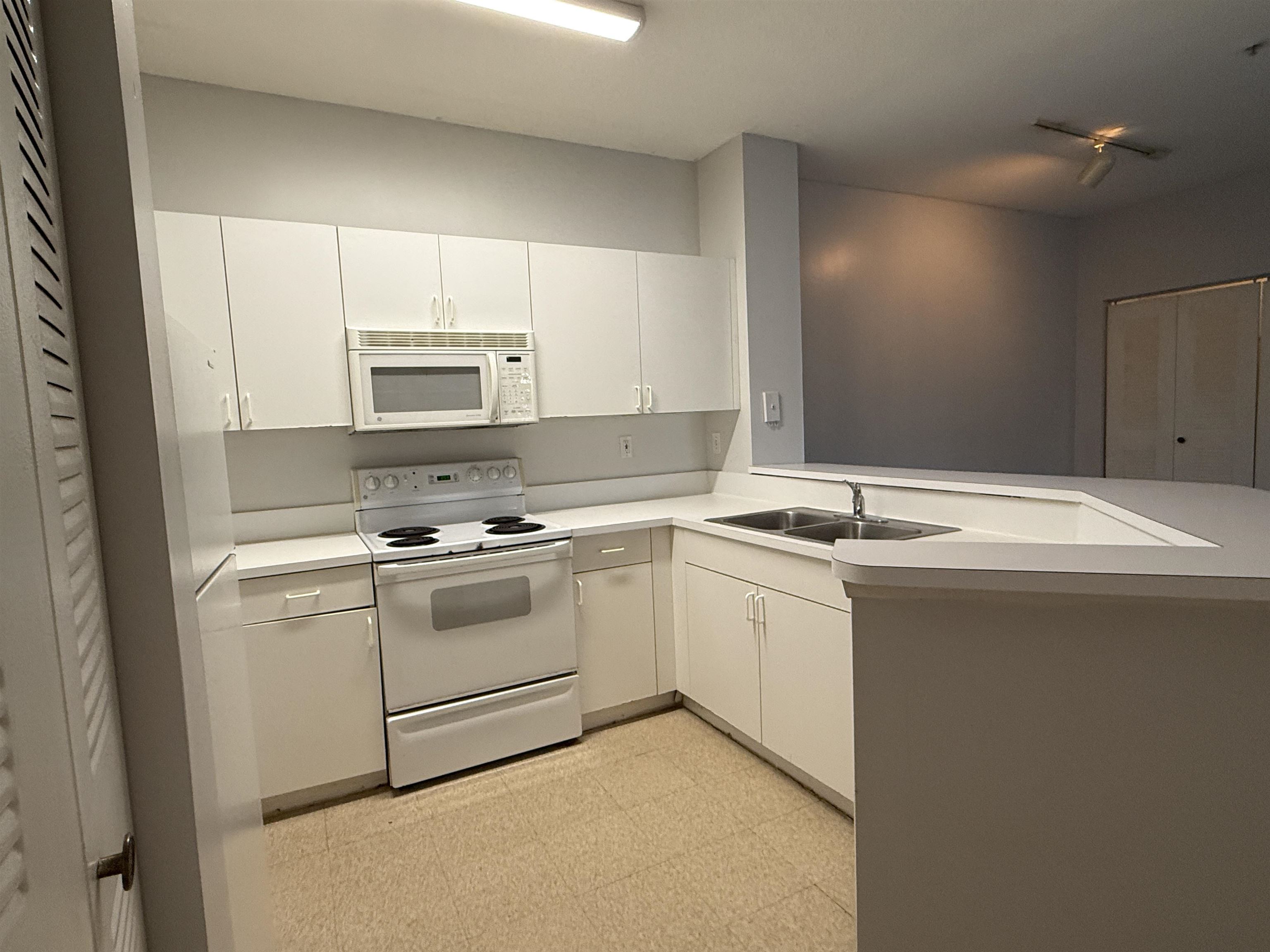 550 Florida Club Boulevard, Unit 205 St. Augustine, FL 32084 - Photo 6 of 10 a kitchen with a sink stove and microwave