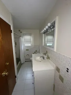 a bathroom with a tub sink and mirror