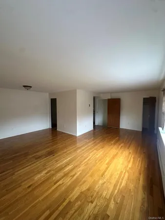 a view of an empty room with closet and a window