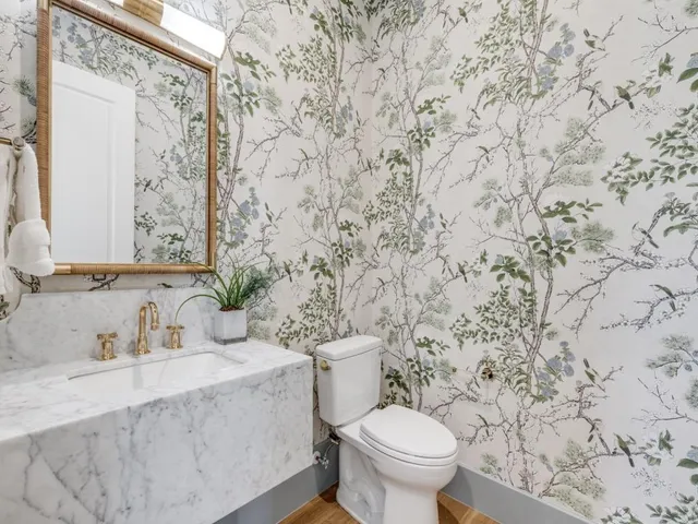 a bathroom with a granite countertop toilet sink and mirror