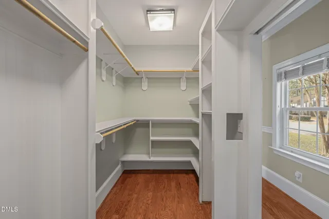 a view of an empty room with a window and cabinet