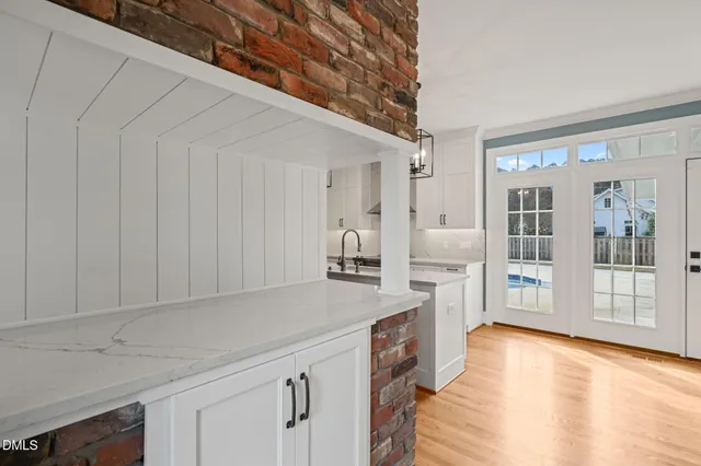 a kitchen with stainless steel appliances granite countertop a sink a stove and a wooden floors