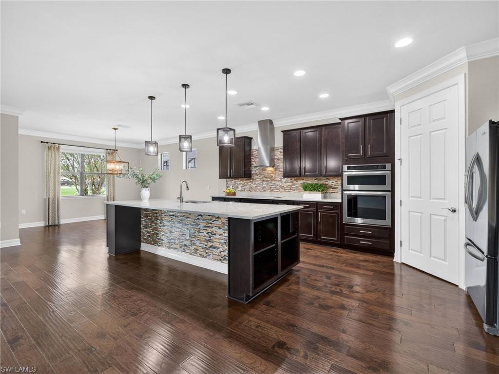 6124 Victory Drive Ave Maria, FL 34142 - Photo 14 of 50 a kitchen with kitchen island granite countertop a large counter top stainless steel appliances and cabinets