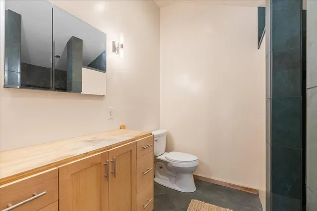a bathroom with a toilet sink and mirror