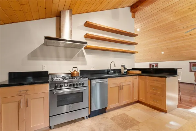 a kitchen with stainless steel appliances granite countertop a stove and a sink