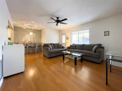 a living room with furniture and a wooden floor