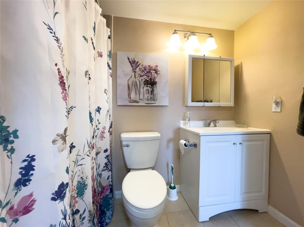 317 Knotty Pine Circle, Unit C2 Greenacres, FL 33463 - Photo 21 of 51 a bathroom with a toilet sink and mirror