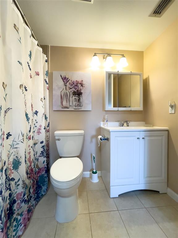 317 Knotty Pine Circle, Unit C2 Greenacres, FL 33463 - Photo 34 of 51 a bathroom with a toilet sink and mirror