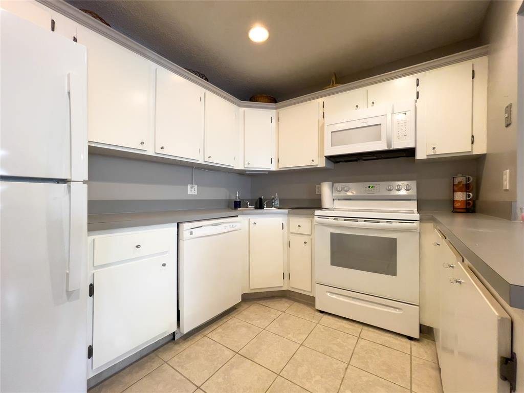 317 Knotty Pine Circle, Unit C2 Greenacres, FL 33463 - Photo 5 of 51 a kitchen with granite countertop white cabinets and white appliances