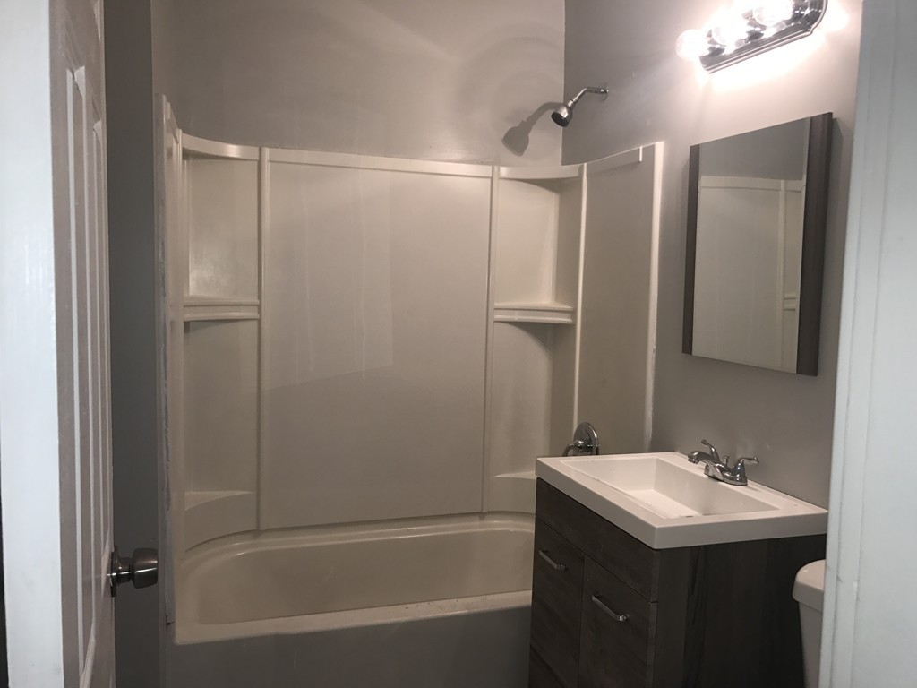 92-94 Draper Street Springfield, MA 01108 - Photo 8 of 25 a bathroom with a bathtub sink vanity and mirror