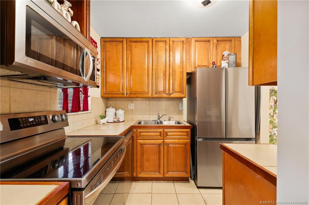 1980 Southwest Palm City Road, Unit 50J Stuart, FL 34994 - Photo 6 of 37 a kitchen with stainless steel appliances granite countertop a stove a sink and a refrigerator