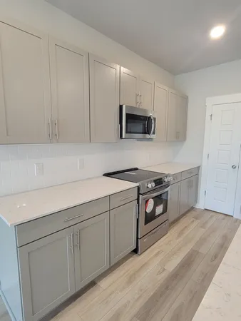 a kitchen with stainless steel appliances white cabinets and a sink