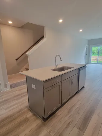 a kitchen with a sink cabinets and wooden floor
