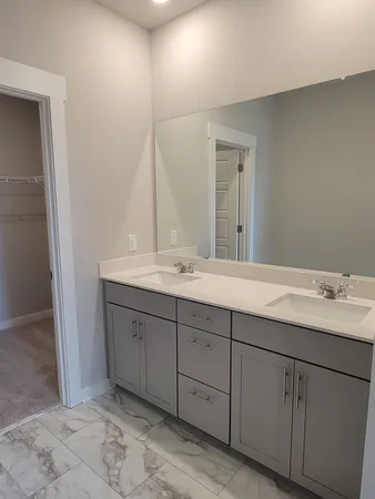 a bathroom with double sink and a mirror