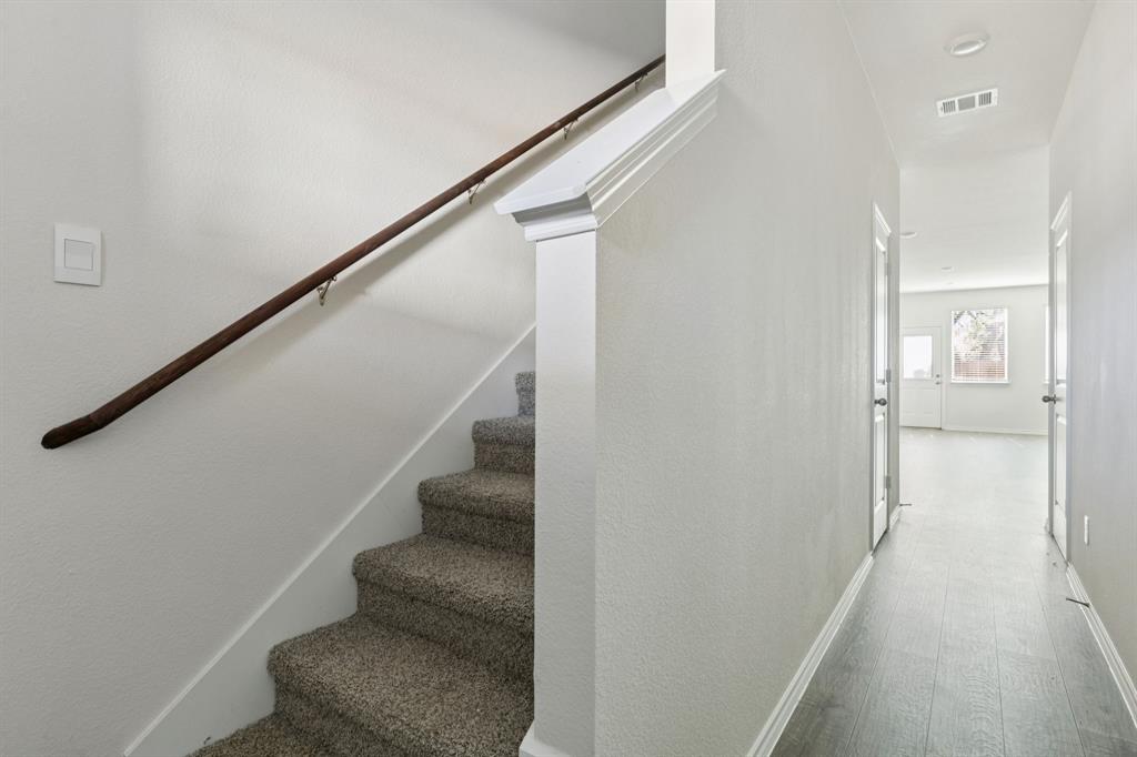 317 Clematis Street Princeton, TX 75407 - Photo 3 of 38 Stairs with baseboards and wood finished floors