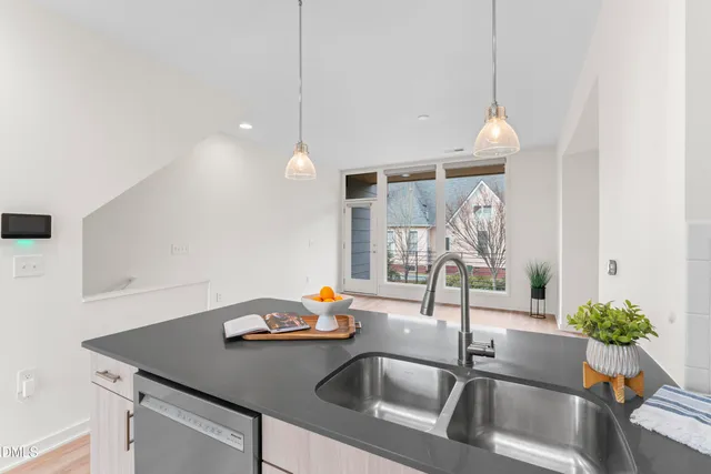 a view of an empty room with wooden floor and stairs
