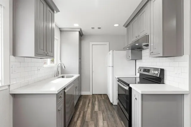 a view of a patio with chairs and table under an umbrella