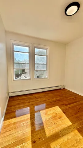 a view of a room with wooden floor and window