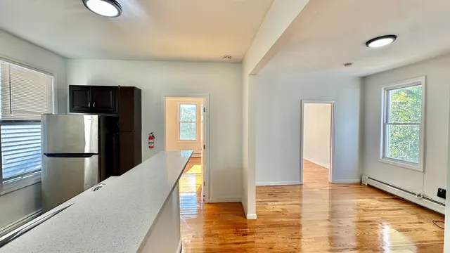 a view of a kitchen with furniture and wooden floor