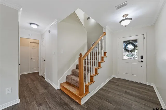 a view of a hallway with wooden floor and staircase