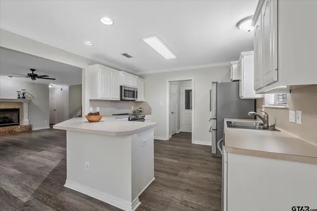 a kitchen with stainless steel appliances a sink stove refrigerator and cabinets