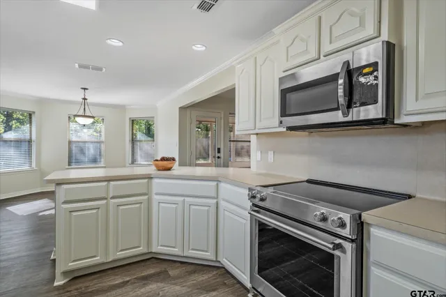 a kitchen with white cabinets stainless steel appliances and sink