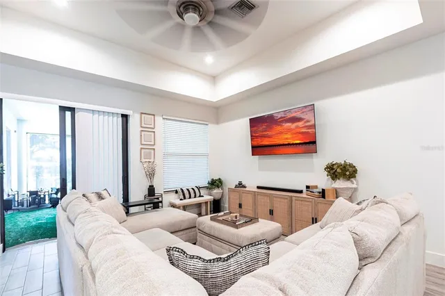 a living room with furniture kitchen view and a flat screen tv