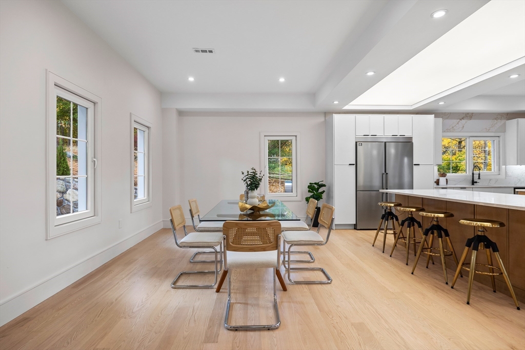 58 Chestnut Street Lynnfield, MA 01940 - Photo 11 of 42 a dining room with wooden floor a glass table and chairs