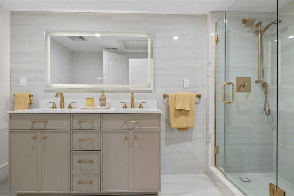 58 Chestnut Street Lynnfield, MA 01940 - Photo 26 of 42 a bathroom with a shower sink and mirror