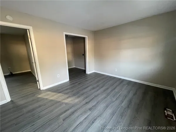 an empty room with wooden floor and closet