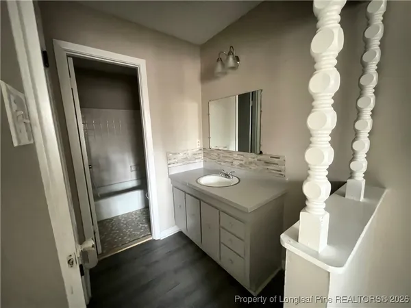 a bathroom with a sink and mirror with toilet