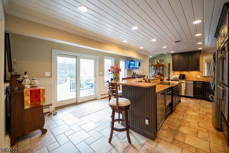 33 Ward Road Blairstown, NJ 07825 - Photo 15 of 49 a kitchen with stainless steel appliances granite countertop a refrigerator a sink dishwasher a stove and white countertops with wooden floor