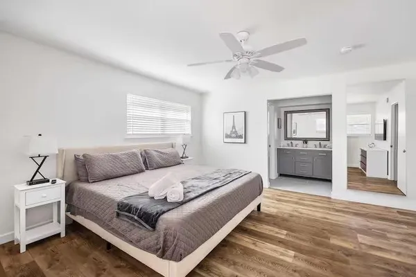 a bedroom with a large bed and a chandelier