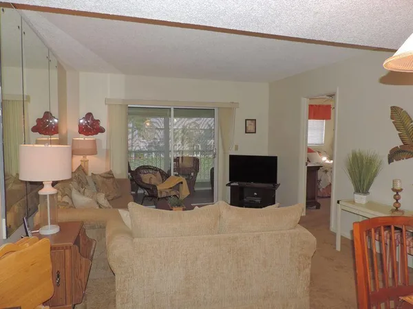 a living room with furniture a flat screen tv and a large window