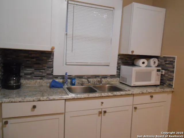 a kitchen with sink and mirror