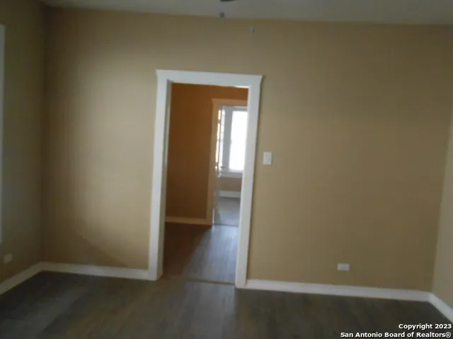 an empty room with wooden floor and closet