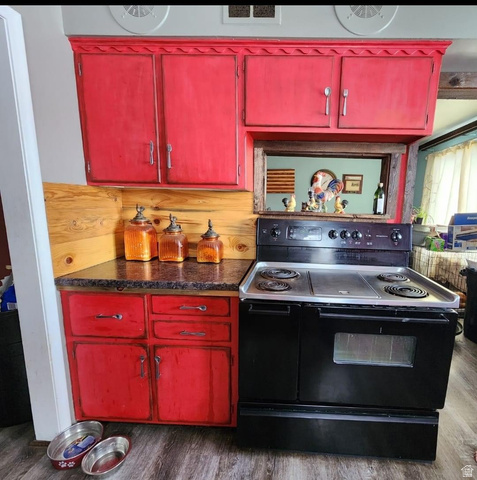 102 South Main Street Paris, ID 83261 - Photo 12 of 33 Kitchen with black electric range, red cabinetry, and dark wood-style floors