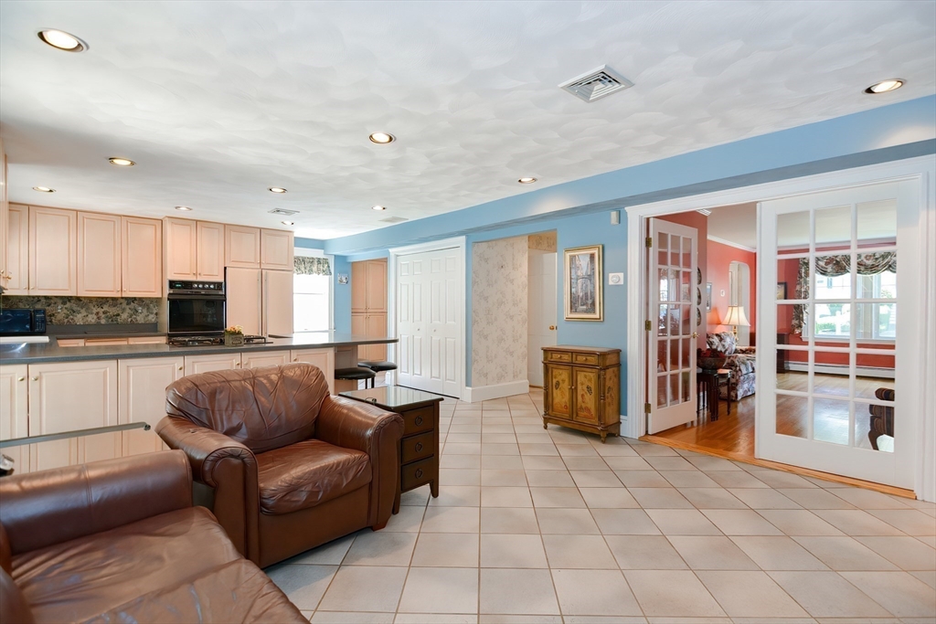 207 Lawrence Road Medford, MA 02155 - Photo 13 of 42 a living room with stainless steel appliances furniture a rug and a kitchen view